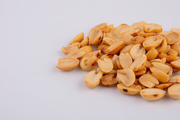 Fried and salted peanuts pile isolated on white background