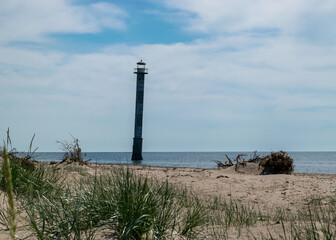 traditional summer landscape with sandy and pebbly promontory, green dune grass, abandoned sloping...