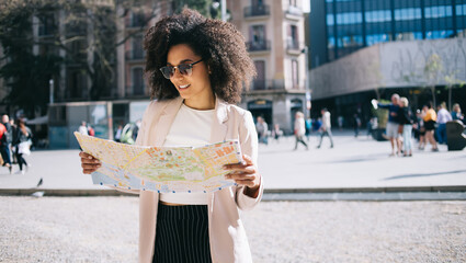 Woman studying map while standing on street