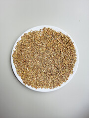 Greenish dried granules of Aniseed, or Pimpinella Anisum seed, or Adas Manis in Indonesia, on a plate