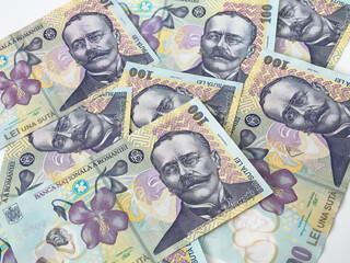 Many 100 RON or lei romanian banknotes on white background. Romanian currency.