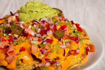 Homemade nachos with vegetable salad hash and guacamole. Closed image
