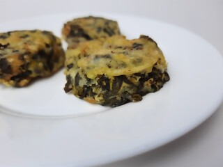 Rolade daun singkong, is a fried food from Indonesia. Made from cassava leaves, tofu and flour. Isolated in white background.