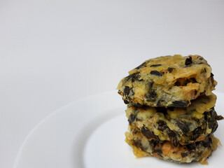 Rolade daun singkong, is a fried food from Indonesia. Made from cassava leaves, tofu and flour. Isolated in white background.