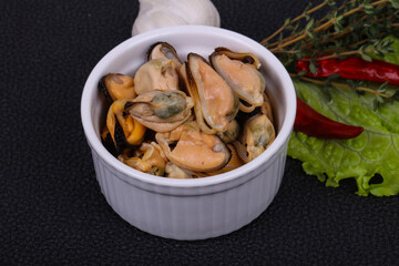Pickled mussels in the bowl served pepper, garlic and salad