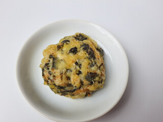 Rolade daun singkong, is a fried food from Indonesia. Made from cassava leaves, tofu and flour. Isolated in white background.