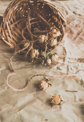 Wicker basket with dry roses. Scattered yellow flowers. - 361481803