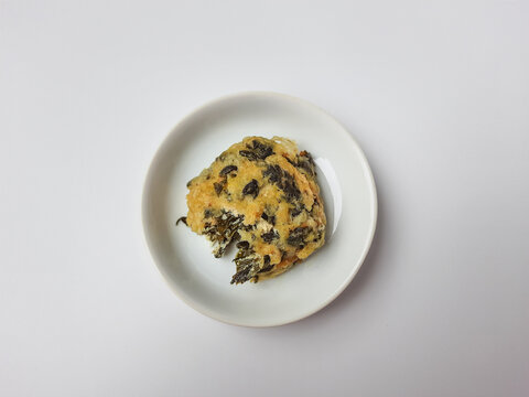 Rolade daun singkong, is a fried food from Indonesia. Made from cassava leaves, tofu and flour. Isolated in white background.