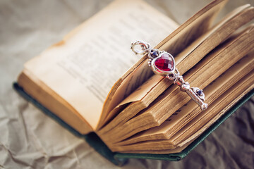 Open book with a beautiful metal key. The key to knowledge. Key with a red heart. Love for learning.
