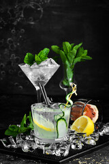 Alcoholic cocktail: Gin and tonic with cucumber on a black stone background. Menu bar. Alcohol.