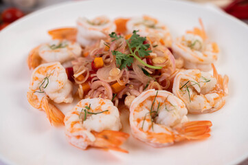 Spicy salad with shrimp on a white plate. Thai food.