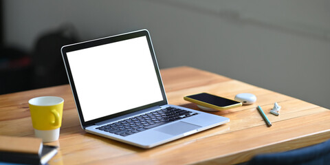 Mockup laptop computer on work table with empty screen.