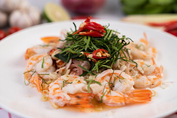 Spicy salad with shrimp on a white plate. Thai food.