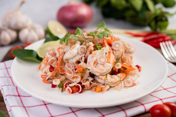 Spicy salad with shrimp on a white plate. Thai food.
