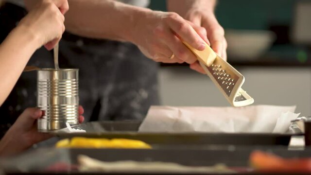 Children cooks pizza. Boy helps father. Prepering ingredients for pizza. Dad rubs cheese on a grater