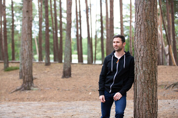 Portrait of a man lean against a tree looking casual
