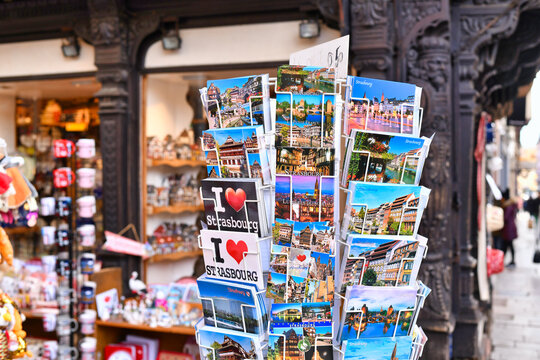 Strasbourg, France -  Rack of postcards in selective focus with  souvenir shop blurred behind in city street of Strasbourg