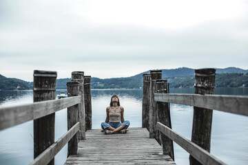 Young woman sitting near the lake