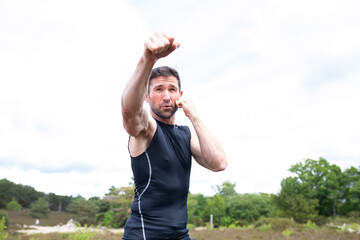Man practicing boxing and sparing in the countryside