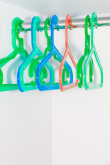 empty multi-colored clothes hangers on the rail, after sale.