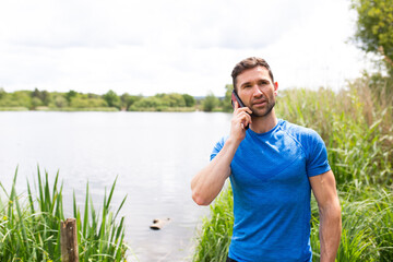 Naklejka na ściany i meble man on the phone by a lake