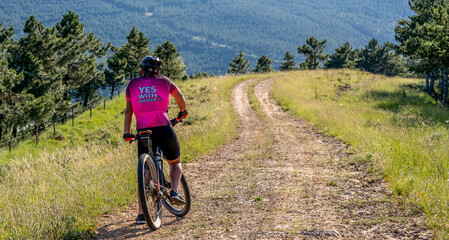 Naklejka premium young guy rides a mountain bike on a pro-cancer mountain tour