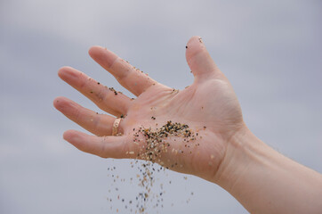 open hand with large sand spilling out of the hand