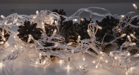 Pine cones wrapped in a luminous garland on the table.