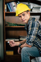 A carpenter holds a paintbrush and paints wood.