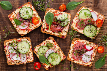 Sandwiches with cream cheese, vegetables and salami.