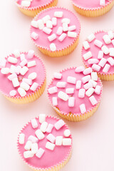 Obraz na płótnie Canvas Colorful cupcakes on a pink background.