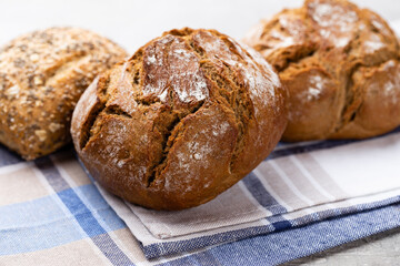 Gold rustic crusty loaves of bread and buns on wooden background. Still life captured from above top view, flat lay.