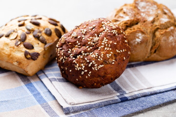 Gold rustic crusty loaves of bread and buns on wooden background. Still life captured from above top view, flat lay.