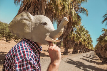 Imagen conceptual de un hombre con cabeza o mascara de elefante haciendo un descanso en el trabajo...