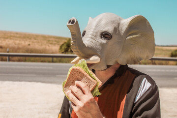person whit mask eating a sandwich © minerva