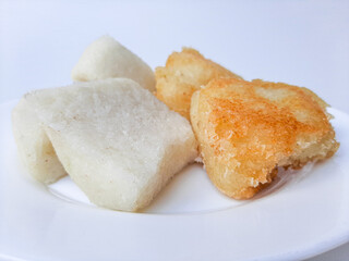 Jadah ketan, is a traditional snack from Indonesia. Made from sticky rice and grated coconut. Comparison before and after fried. On a white plate, isolated in white background