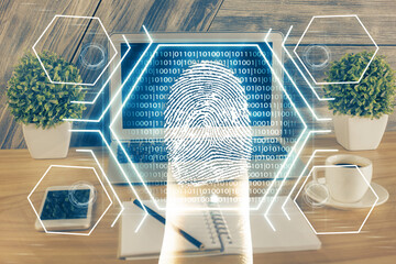 Fototapeta premium Computer on desktop in office with finger print drawing. Double exposure. Concept of business data security.