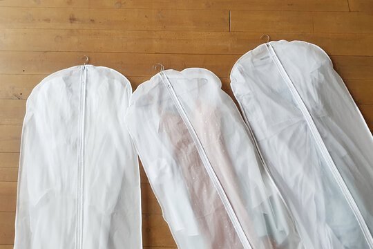 Three White Hanging Garment Bag On The Floor. The Morning Before The Wedding. Pack Your Things On A Trip Or Sort And Hang Up Your Wardrobe.