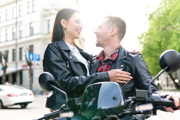 Stylish couple with a motorcycle on a city street