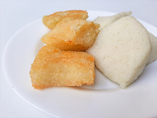 Jadah ketan, is a traditional snack from Indonesia. Made from sticky rice and grated coconut. Comparison before and after fried. On a white plate, isolated in white background
