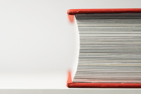 Closed book with red book cover. Close-up. Side view.