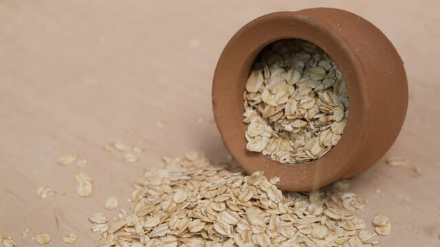 Rolled oats grains in a faience pot. 4k video shot.