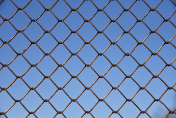 Metallic fence net against the sky