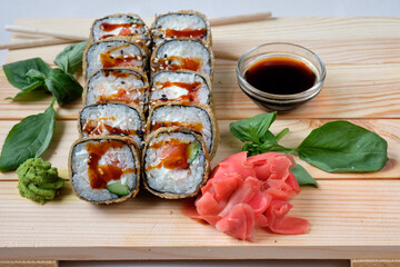Sushi rolls with soy sauce, wasabi and basil. traditionally made with medium-grain white rice. Japanese sticks. Restaurant menu image.