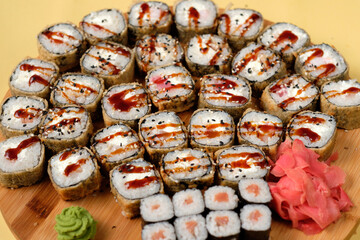 Fresh assorted Japanese sushi rolls with pickled ginger and wasabi on the wooden board. Restaurant or cafe menu images. Food photography. Top view.