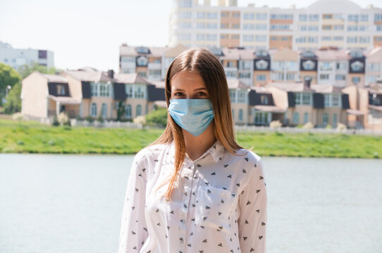 Masked Woman On The River Bank In A European City. Travel And Leisure In Covid 19 And Quarantine Restrictions