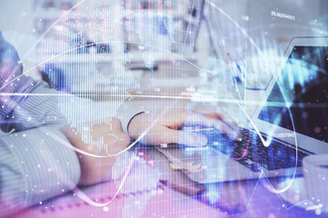 Multi exposure of businessman working on laptop on background. International business hologram in...