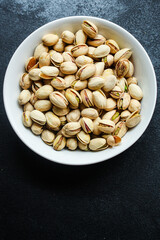pistachios tasty nuts snack Menu concept serving size. food background top view copy space for text organic healthy eating keto or paleo diet