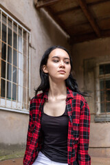 portrait of a beautiful girl on the street of the city. She has long dark hair, beautiful eyes, naturalness on. Ordinary girl from the city. High quality photo