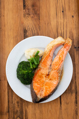 fried salmon trout with boiled vegetables on the dish